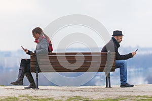 man and woman sitting apart on a bench