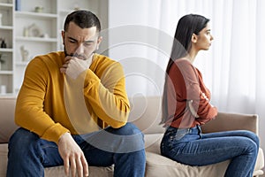 Man and woman sitting apart looking upset