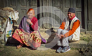 Man and woman sitting on the curb watching people go by, Bhaktapur, Nepal