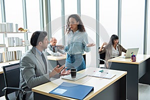 A man and a woman are sitting and discuss at a table chatting to a work colleague