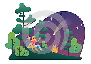 Man and woman sitting on the grass at the campfire