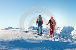 Man and woman ski tourer enjoying the view on a summit in the alps.