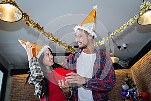 Man and woman snile and holding red heart pillow on hand in the party, concept of love and celebrate photo