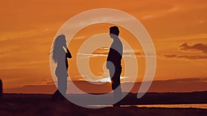 Man and woman spinning hold hands. silhouette man and girl of a happy young married couple slow dancing outside at