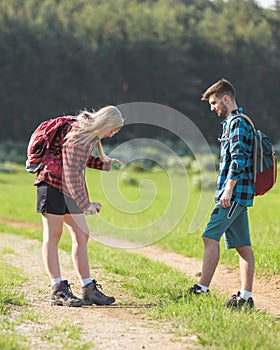 Man and woman spraying with tick repellent in nature