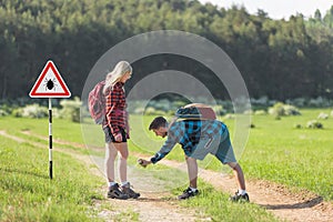 Man and woman spraying with tick repellent in nature