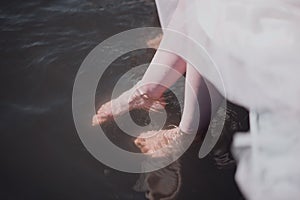 Man and woman stand with their feet in the water in the river