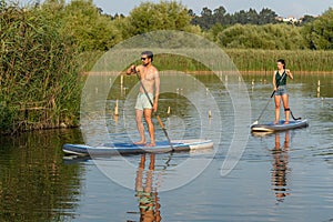 Man and woman stand up paddleboarding