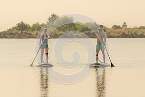 Man and woman stand up paddleboarding