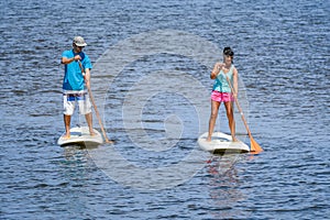 Man and woman stand up paddleboarding