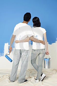 Man and woman standing and looking at painted wall. Conceptual image