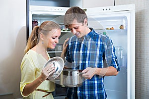 Man and woman standing near fridge photo