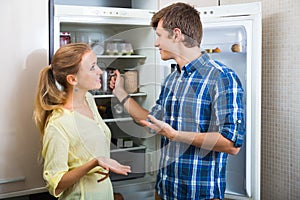Man and woman standing near fridge photo