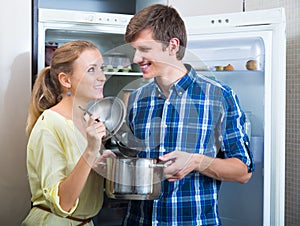 Man and woman standing near fridge photo