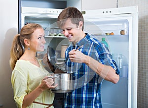 Man and woman standing near fridge photo