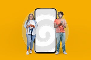Man and Woman Standing Next to Giant Phone