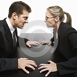 Man and woman staring at each other with hostile expressions.