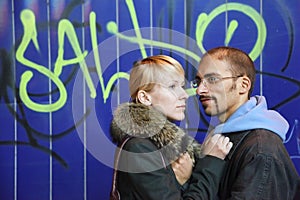 Man and woman is staying near graffiti wall photo