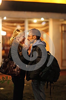 man and woman is staying near restaurant.