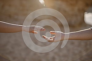 Man and woman stretching hands to each other at the beach