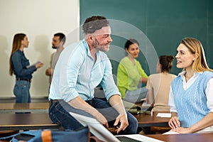 Man and woman students having conversation during recess