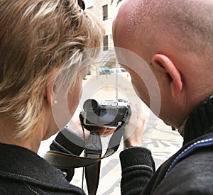 The man and the woman study the camera.