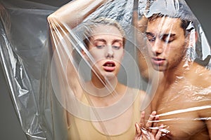 Man and woman suffocate from living in plastic bag, plastic waste concept