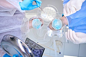 Man and woman in surgical uniforms are in operating room