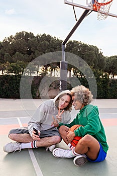 Man and woman taking selfie after play basketball