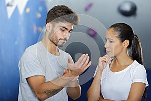 man and woman talking at indoor climbing gym wall