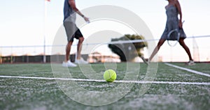 Man and woman tennis players shaking hands in middle of tennis court against background of ball and net