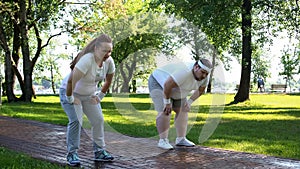 Man and woman tired after jogging in park, fitness weight loss program, cardio