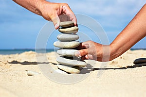 Man and woman together to build a tower made of stones.
