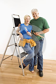 Man and woman with tools and ladder.