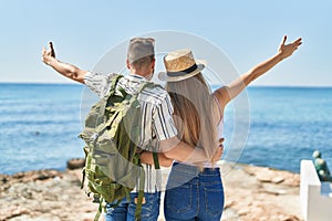 Man and woman tourist couple hugging each other on back view at seaside