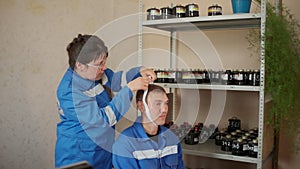 Man and woman in uniform of emergency service. Clip. Woman measuring the head size of a man.