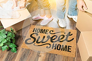 Man and Woman Unpacking Near Home Sweet Home Welcome Mat, Moving