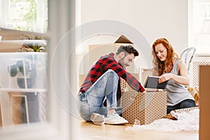 Man and woman unpacking stuff after relocation to new home