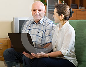 Man and woman using laptop at home