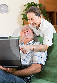 Man and woman using laptop at home