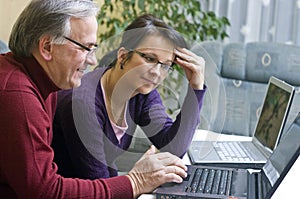 Man and woman using laptops