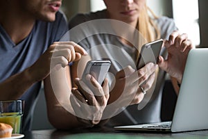 Man and woman using smartphones discussing mobile apps, close up photo