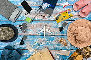 Man and woman vacation accessories on the blue wooden boards. Plane in center