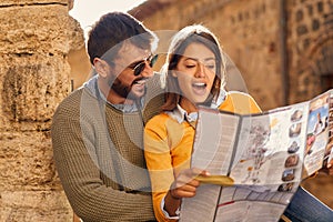 Man and woman on vacation sightseeing city with map photo