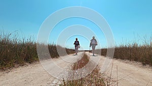 A man and a woman walk along the road on Kinburn Spit on a hot summer day