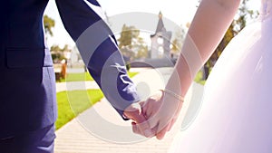 Man and woman walking in the park holding hands. newly married couple walk together holding hands