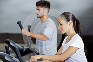 Man and woman walking on treadmills in modern gym