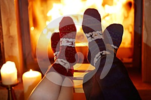 Man and woman in warm socks near fireplace