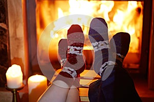 Man and woman in warm socks near fireplace