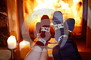 Man and woman in warm socks near fireplace